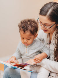 Mother and son reading book at home