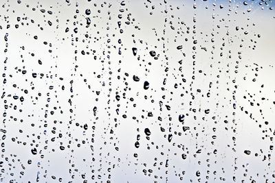 Low angle view of raindrops against sky