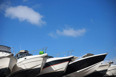 Low angle view of boats moored against blue sky