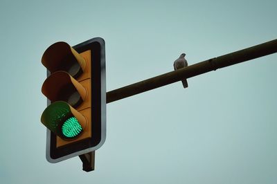 Low angle view of road sign against clear blue sky