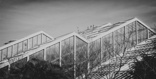 Low angle view of bridge by building against sky