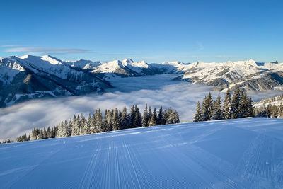 Scenic view of snow covered mountains in saalbach hinterglemm in the austria against blue sky 