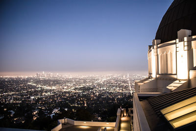 High angle view of illuminated buildings against clear sky