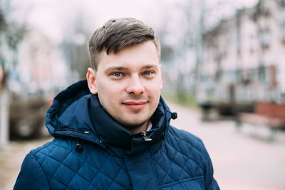 Portrait of man standing on footpath against sky