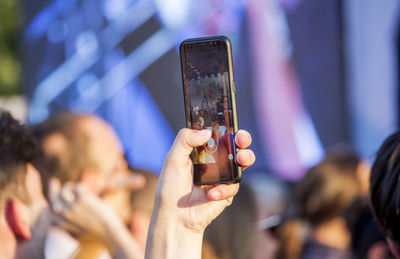 Midsection of woman holding mobile phone outdoors