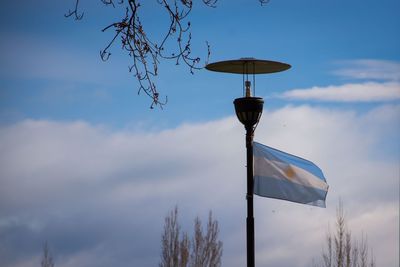 Low angle view of pole against cloudy sky