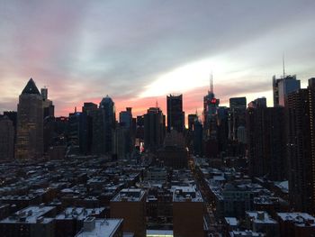 Aerial view of buildings in city during sunset