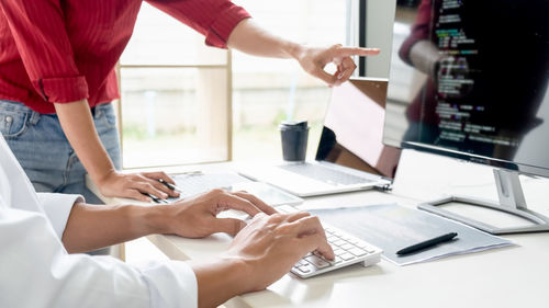 Midsection of woman using laptop on table