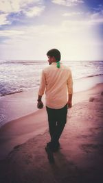 Rear view of man standing on beach