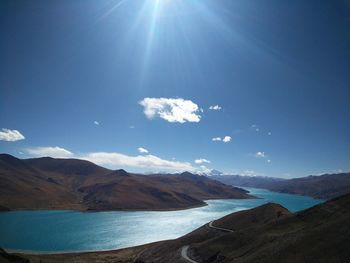 Scenic view of mountains against blue sky on sunny day