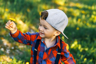 Full length of boy holding hat