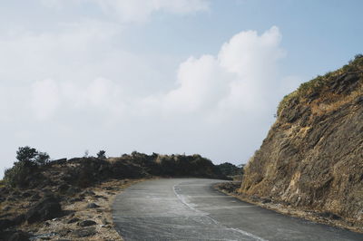 Road amidst rocks against sky