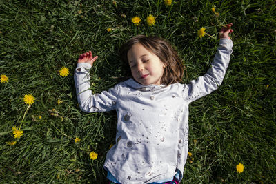 Above-view of peaceful child laying in field of wildflowers in spring