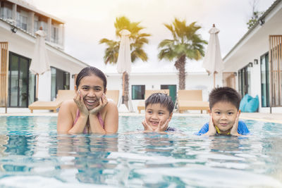 Mother and sons enjoying in swimming-pool on summer season.