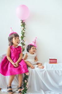 Portrait of cute girl with pink balloons