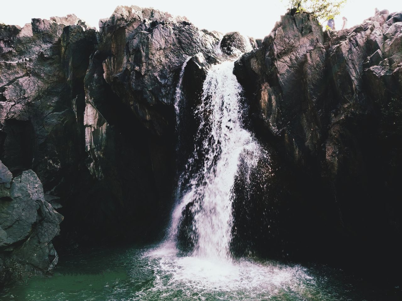 SCENIC VIEW OF WATERFALL AGAINST ROCKS