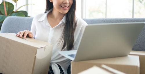 Young woman using mobile phone in box