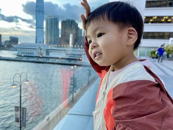 Portrait of asian boy standing by railing