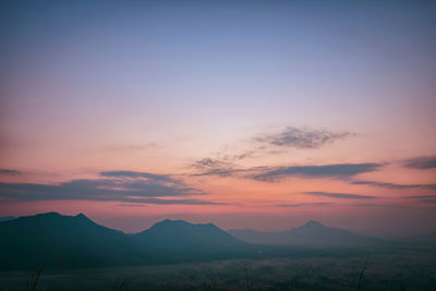 Scenic view of silhouette mountains against romantic sky at sunset