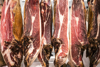 Close-up of raw meat hanging in store