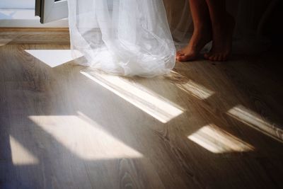 Low section of woman with dress on hardwood floor