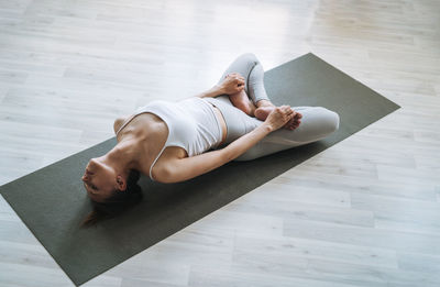 Low section of woman doing yoga at home