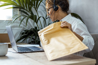 Side view of man using laptop on table