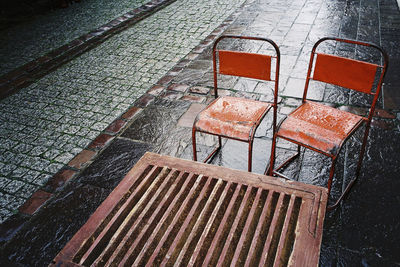 High angle view of empty chairs on sidewalk