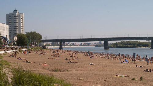 Group of people on beach against clear sky