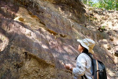 Rear view of man standing on rock formations