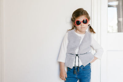 Portrait of cute girl standing in sunglasses