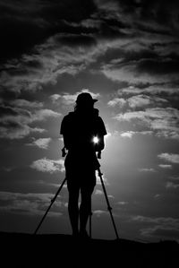 Rear view of silhouette man standing against sky