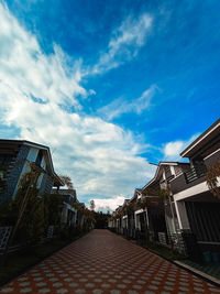 Street amidst buildings in town against sky