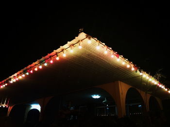 Low angle view of illuminated bridge against clear sky at night