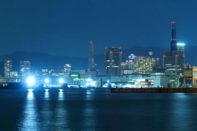 River with illuminated buildings in distance at night