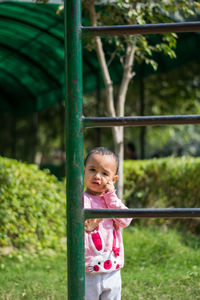 Cute girl standing by exercise equipment