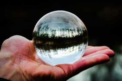 Close-up of hand holding glass of crystal ball