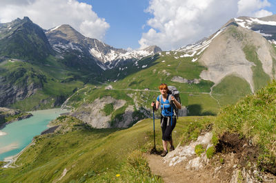 Woman hiking on mountain against sky