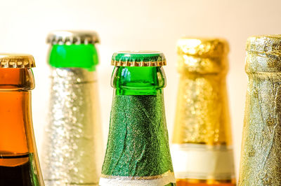 Close-up of beer bottles against wall