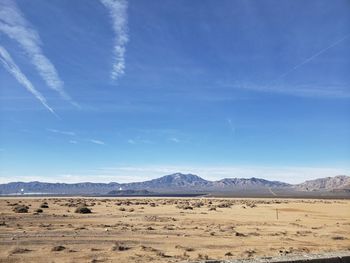 Scenic view of desert against blue sky