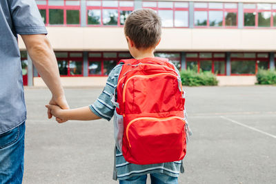 School concept. dad walks his son with a backpack on his back to school. 