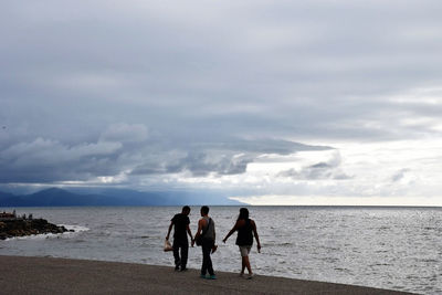 Men on beach against sky