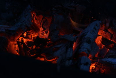 Smoldered logs burned in vivid fire close up. atmospheric background with flame.