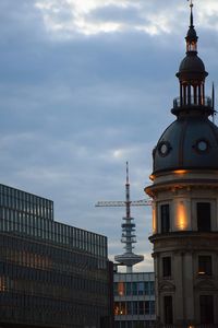 Buildings in city against cloudy sky