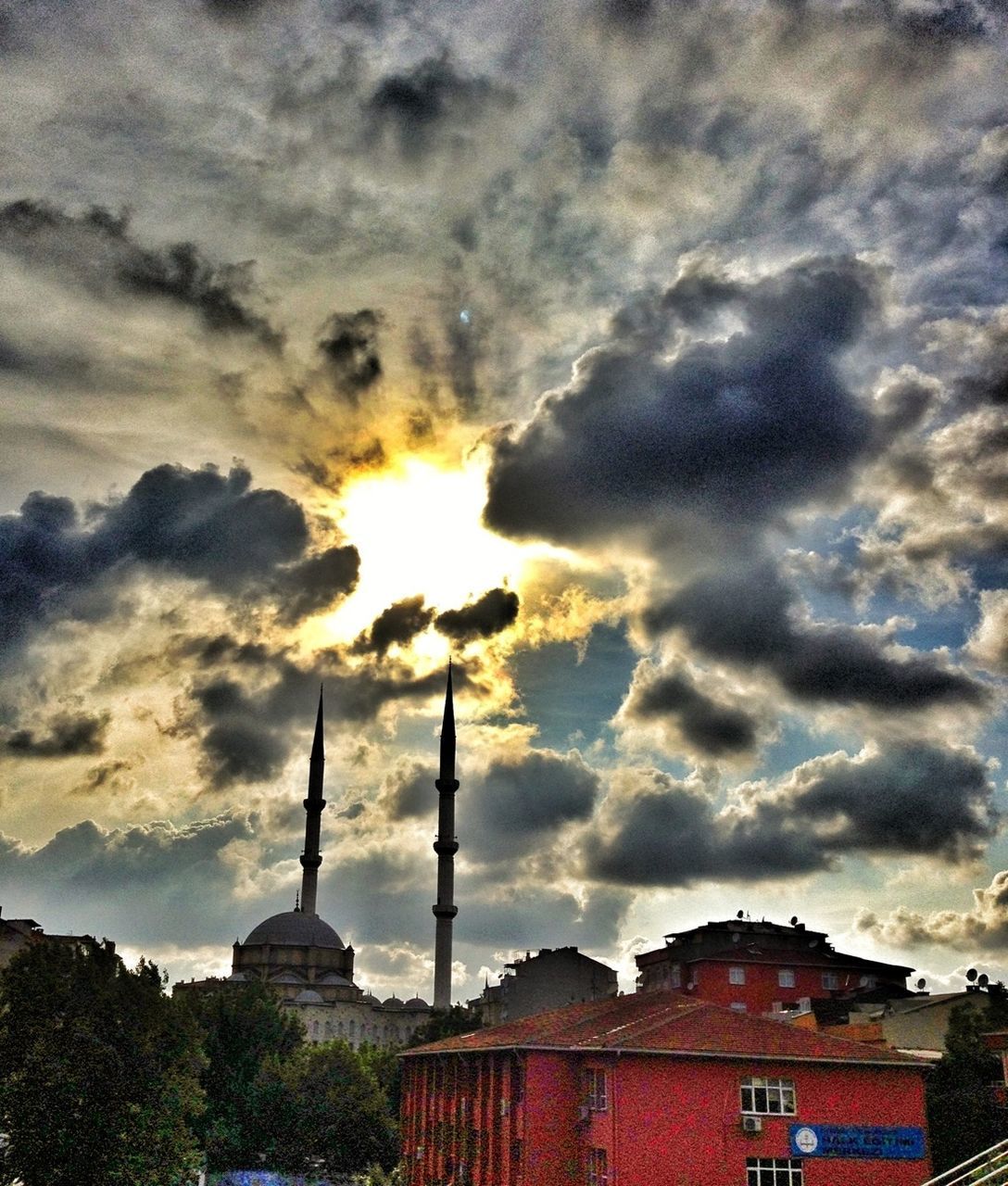 building exterior, architecture, built structure, cloud - sky, sky, cloudy, sunset, weather, cloud, low angle view, dramatic sky, orange color, overcast, religion, smoke stack, outdoors, storm cloud, no people, spirituality