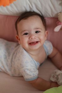 Portrait of cute baby lying on bed
