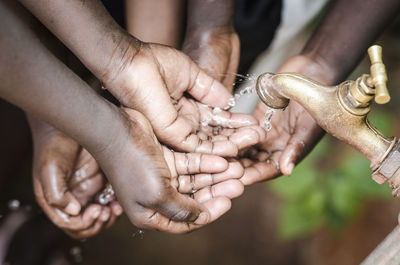 Cropped image of people washing hands