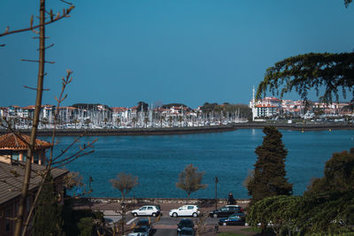 Scenic view of sea and buildings against clear blue sky