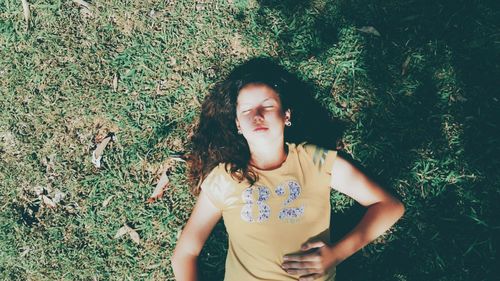 Young woman standing on field against trees