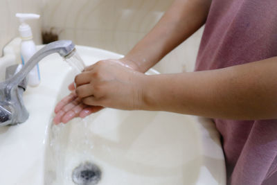 Midsection of woman in bathroom at home